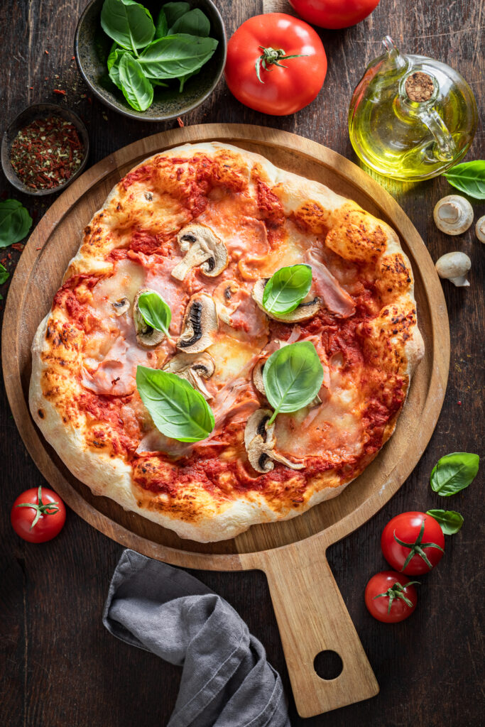 Hot Capricciosa pizza on wooden table. Poster for Restaurant.
